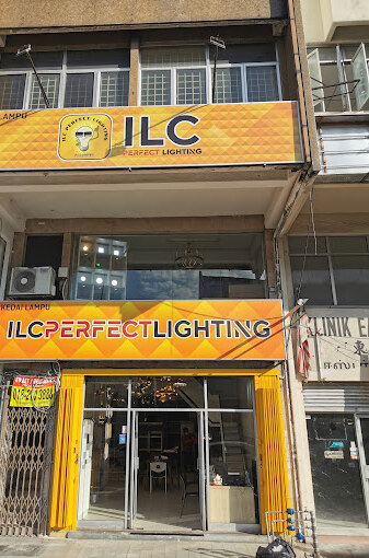 Shophouse with orange-yellow fascia signs reading Kedai Lampu ILC Perfect Lighting above a glass shopfront with chandeliers inside