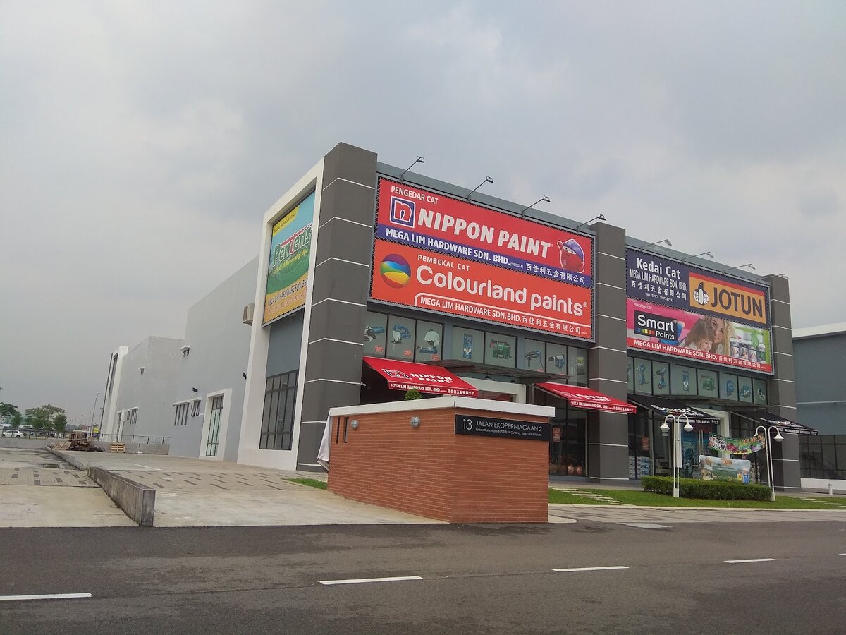 Grey two-storey shop with large Nippon Paint, Colourland, Jotun and Smart Paints signboards reading Mega Lim Hardware Sdn. Bhd.