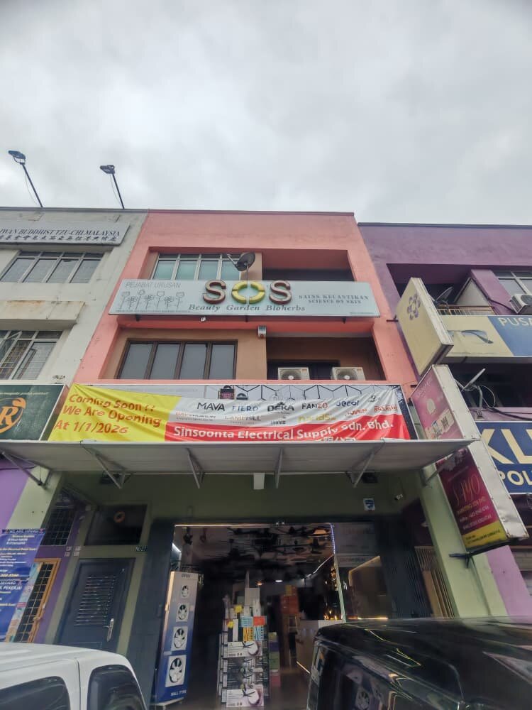 Three-storey pink shophouse with a yellow and red banner reading Coming Soon, We Are Opening At 1/1/2026, Sinsoonta Electrical Supply Sdn Bhd, above an open shopfront with fans and boxes inside