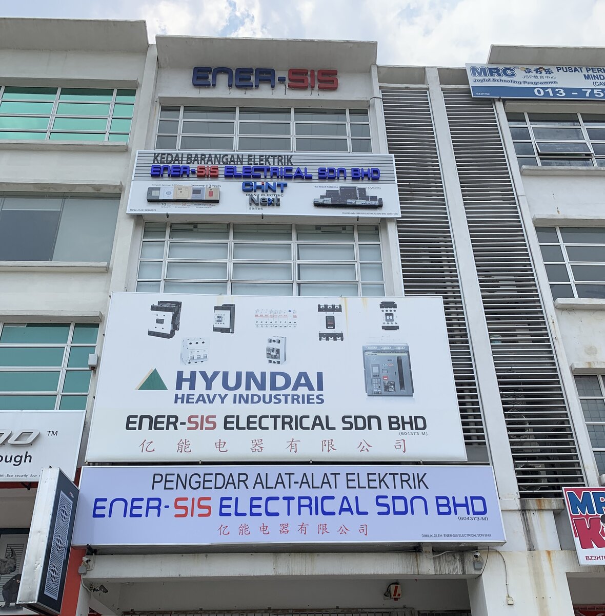 Three-storey shop-office with an Ener-Sis Electrical signboard, a large Hyundai Heavy Industries panel and a CHINT NEXT series sign