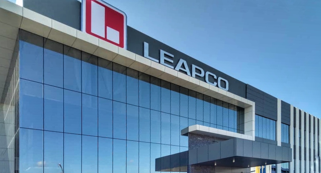 Glass-fronted factory office with a large Leapco logo and name on the facade
