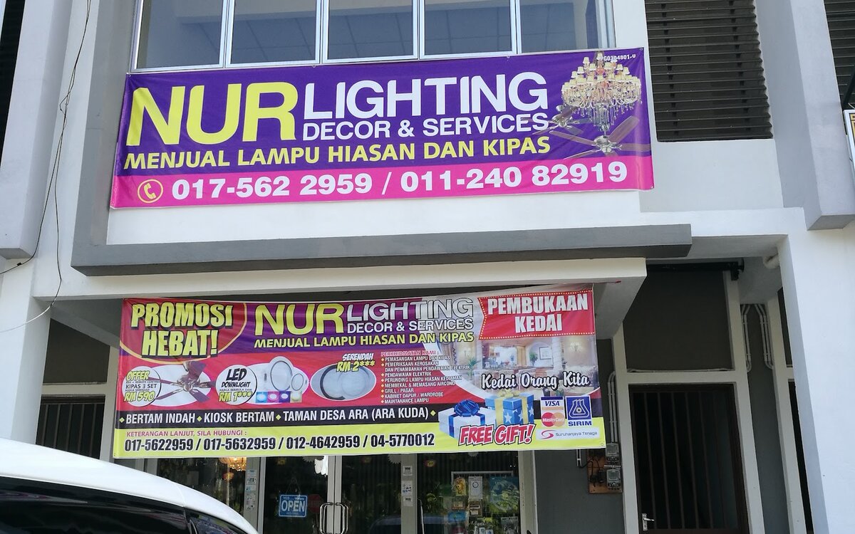 Shophouse with a purple Nur Lighting banner on the upper floor and a promotional shop-opening banner over the glass shopfront