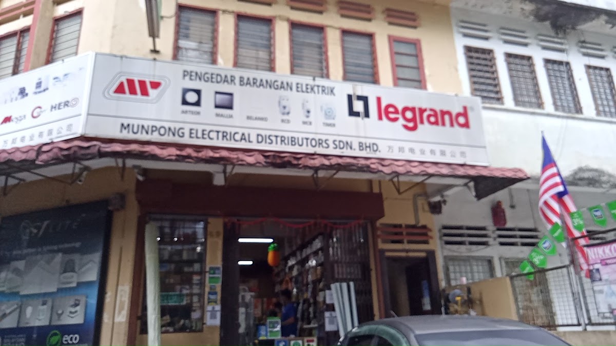Shophouse with a white Munpong Electrical Distributors signboard carrying a large red Legrand logo