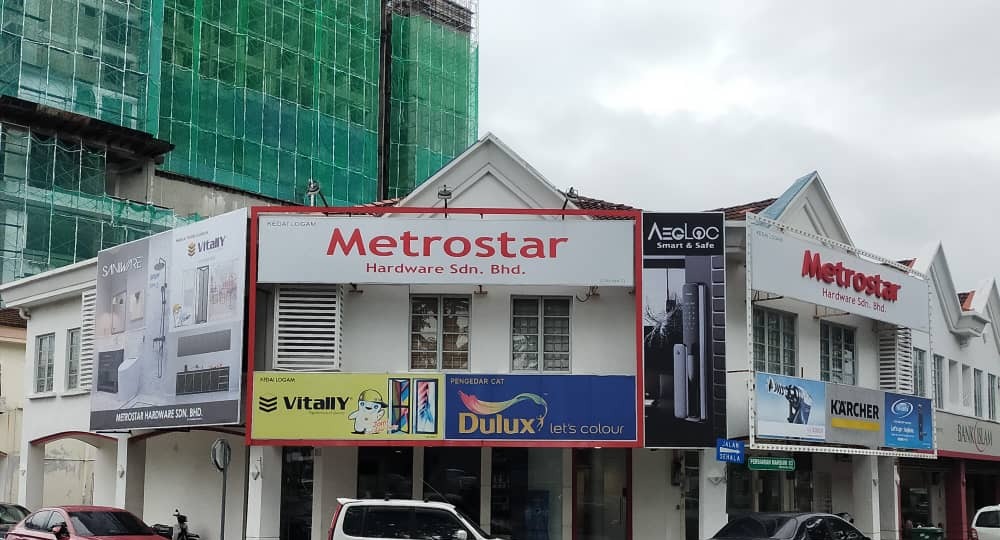 White two-storey corner shophouses with red Metrostar Hardware signboards and paint, door and smart-lock advertising panels
