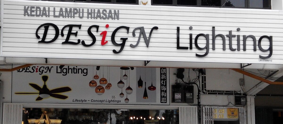 White slatted fascia reading Kedai Lampu Hiasan Design Lighting above a banner of pendant lamps and a ceiling fan