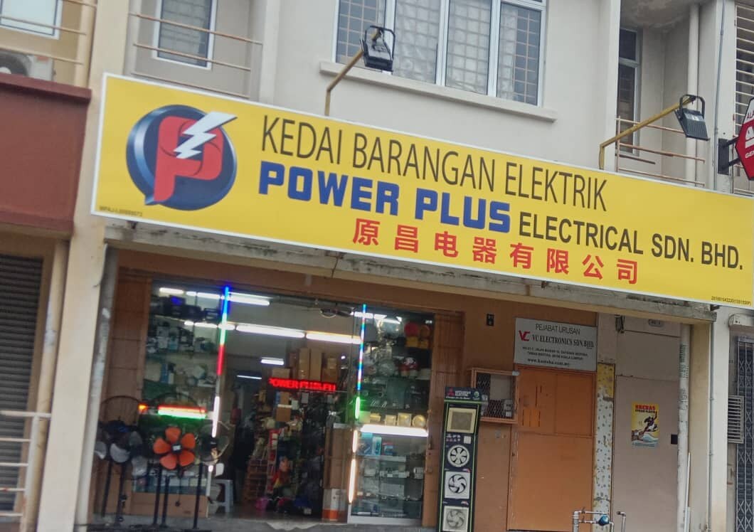 Shophouse with a yellow signboard reading Power Plus Electrical Sdn Bhd, fans at the door and a ventilation-fan display stand
