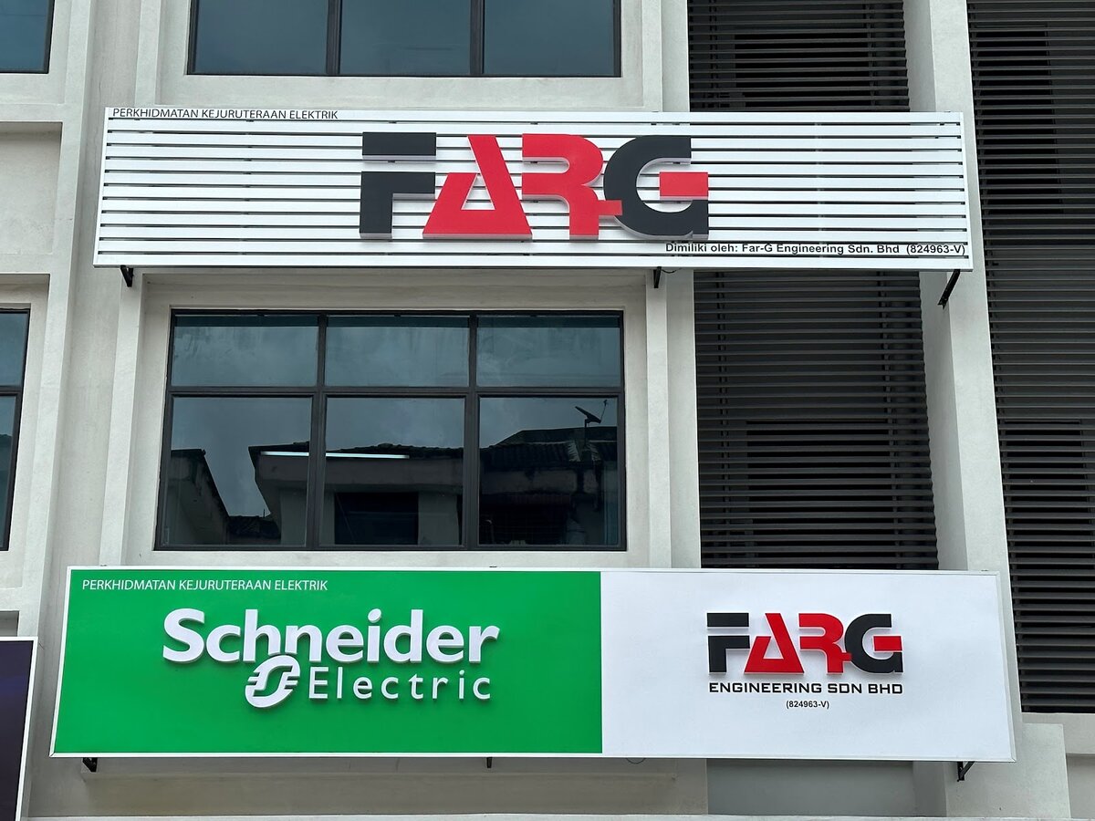 White slatted signboard with the red and black FARG logo above a green Schneider Electric and white FARG Engineering Sdn Bhd signboard on a shoplot facade
