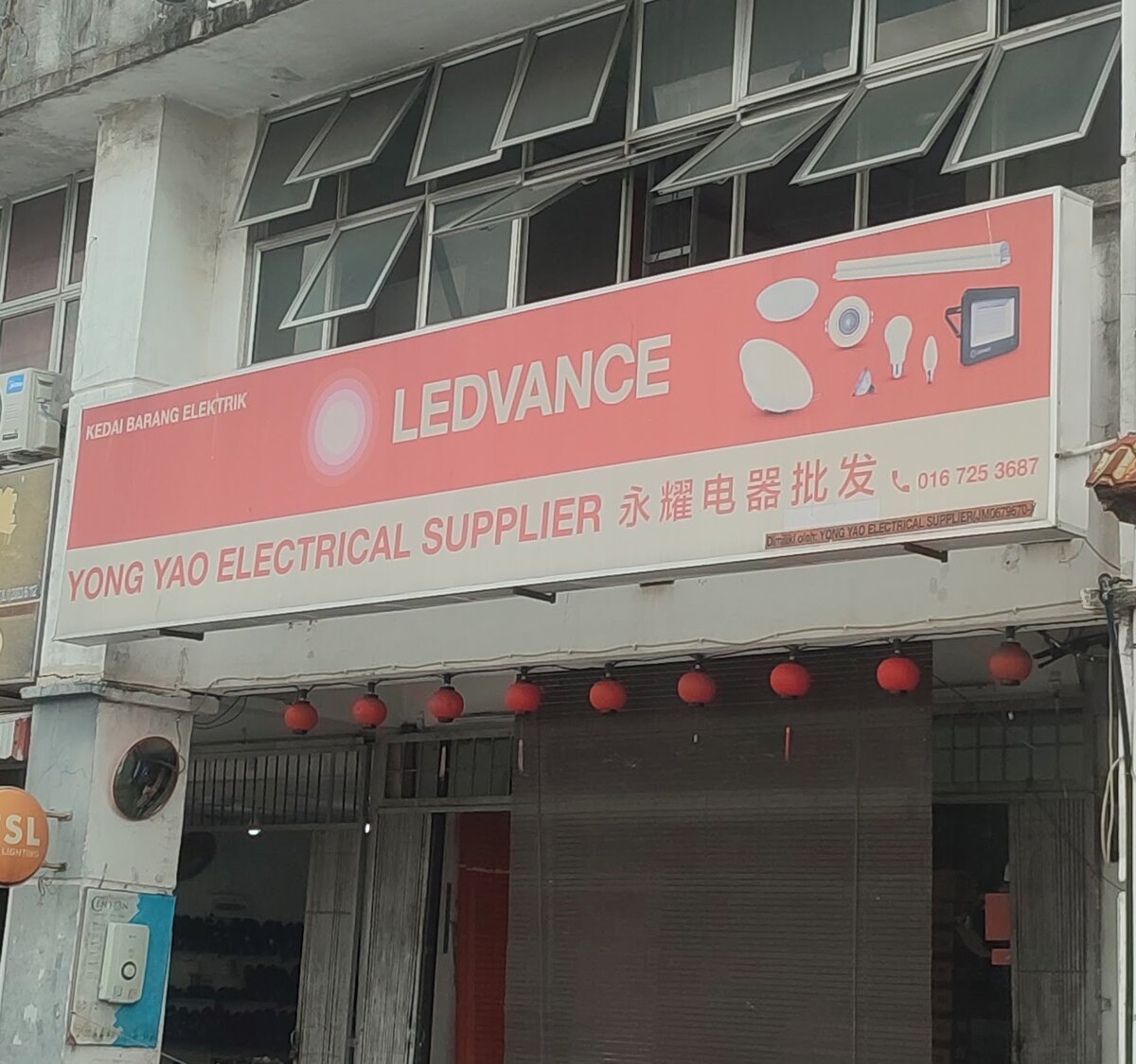 Shophouse with a salmon-coloured Ledvance signboard reading Yong Yao Electrical Supplier, red lanterns and closed shutters