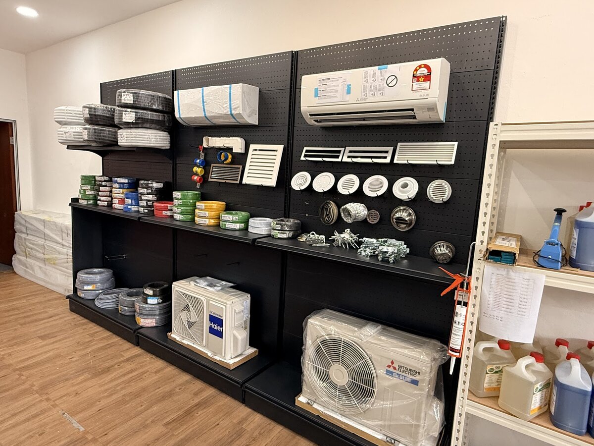 Black pegboard display with coloured cable coils, grey flexible conduit, aircond indoor and outdoor units, air grilles and round diffusers
