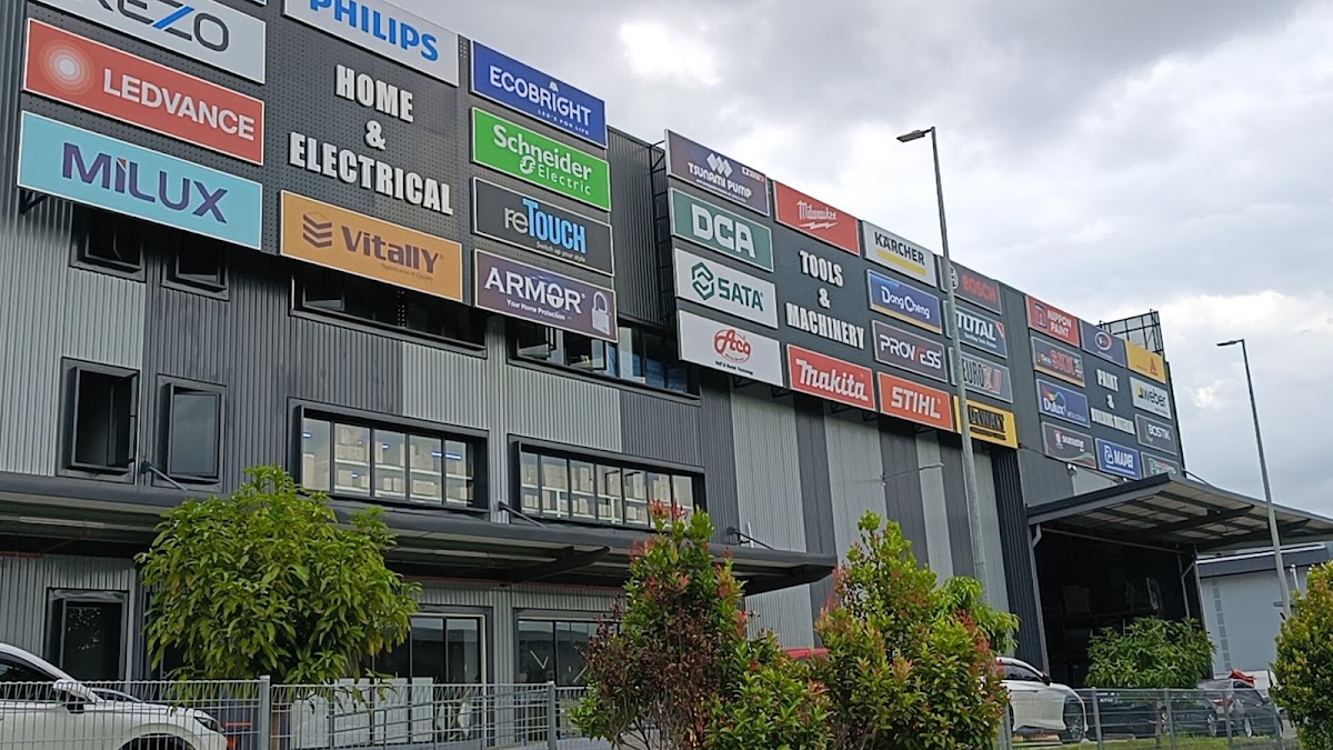 Grey warehouse-style store with rows of brand panels including Philips, Ledvance, Schneider Electric, Makita and Stihl, and HOME & ELECTRICAL and TOOLS & MACHINERY section signs