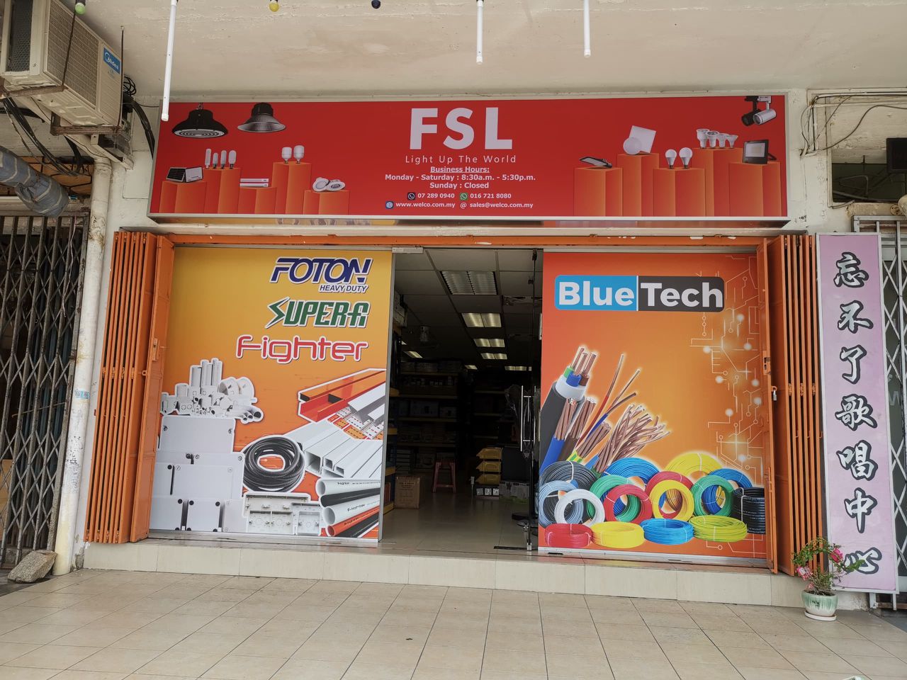 Shopfront with a red FSL signboard and orange posters for Foton, Super-A, Fighter and BlueTech