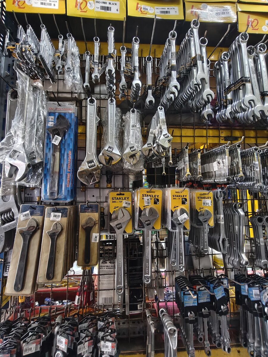 Pegboard wall of spanners, adjustable wrenches and other hand tools in blister packs