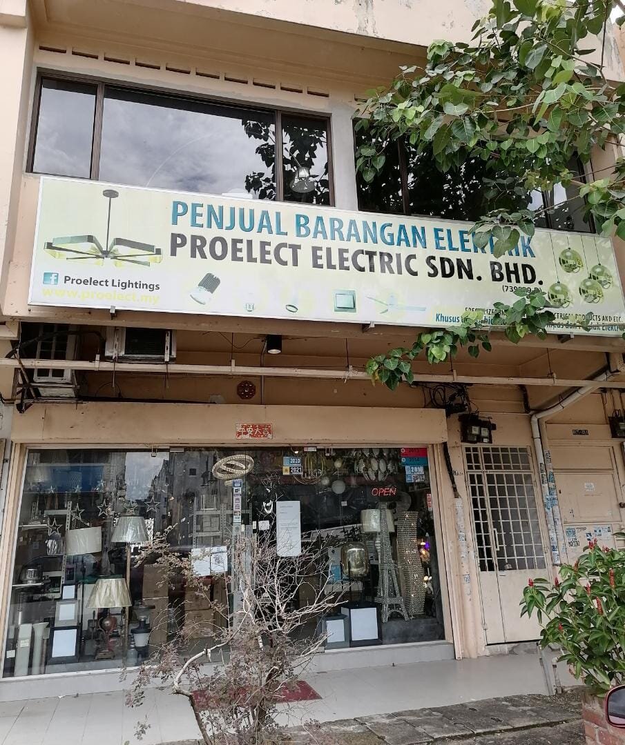 Two-storey shoplot with a pale signboard reading Proelect Electric Sdn. Bhd. above a glass shopfront showing lamps