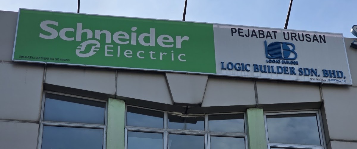 Signboard with a green Schneider Electric panel on the left and Pejabat Urusan Logic Builder Sdn. Bhd. with the company logo on the right