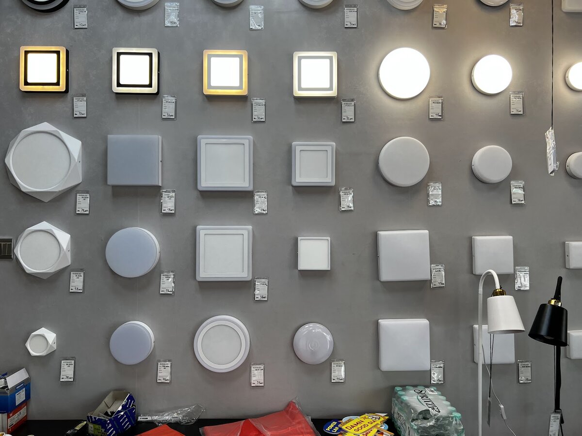Grey display wall covered with round and square LED ceiling lights of different sizes
