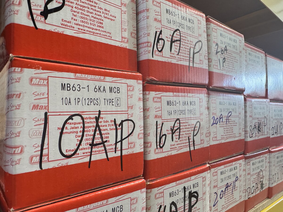Stacked red and white Maxguard cartons labelled MB63-1 6KA MCB with handwritten ratings such as 10A 1P and 16A 1P