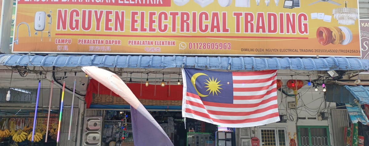 Orange Nguyen Electrical Trading signboard above a shopfront hung with lights
