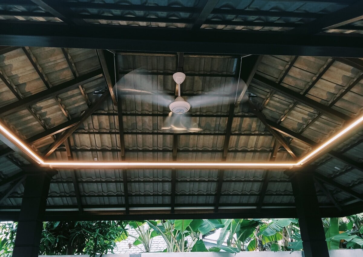Underside of a tiled gazebo roof with a white ceiling fan in the centre and a warm LED strip running around the edge of the roof frame