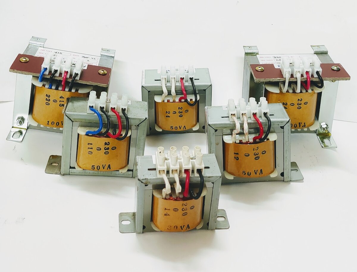 Six small open-frame transformers with copper windings and terminal blocks, labelled with voltages such as 0 230 with 12, 14, 24 and 110 taps and ratings from 30 VA to 100 VA