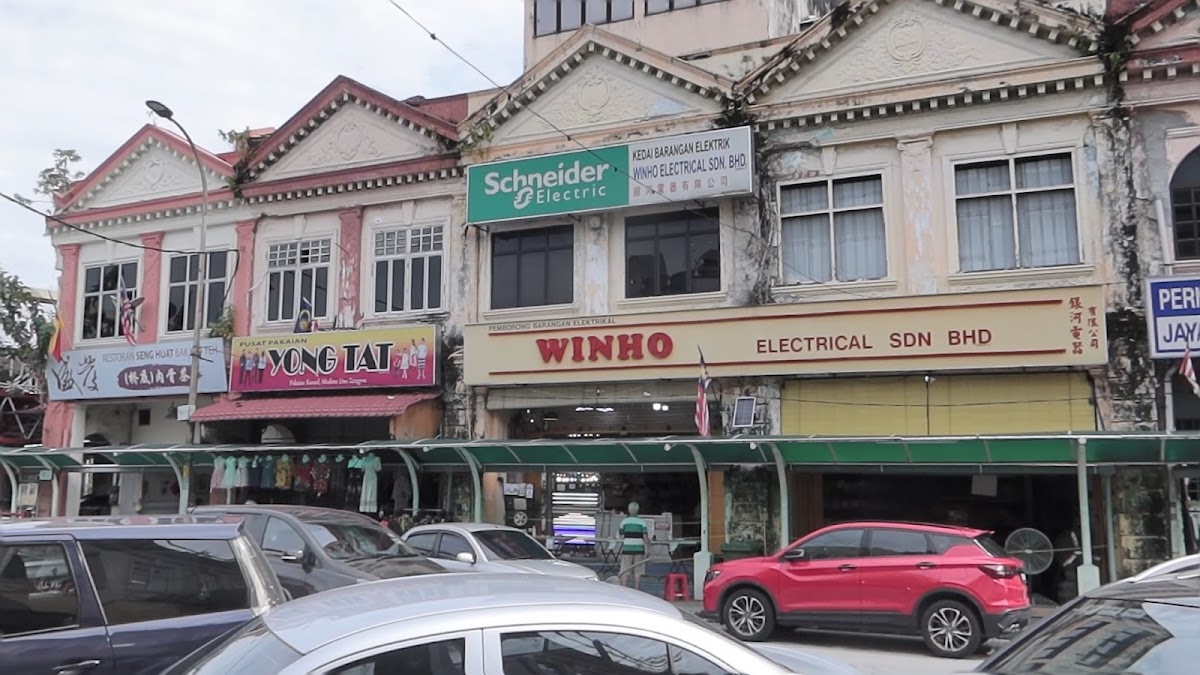 Row of heritage shophouses with a Schneider Electric sign and a long Winho Electrical Sdn Bhd signboard