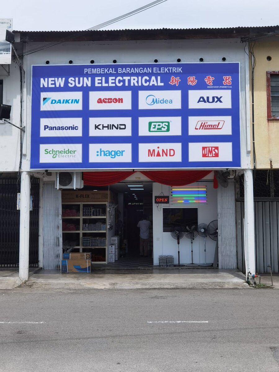 Shophouse front under a blue New Sun Electrical signboard with twelve brand logo panels, an open door and an OPEN sign