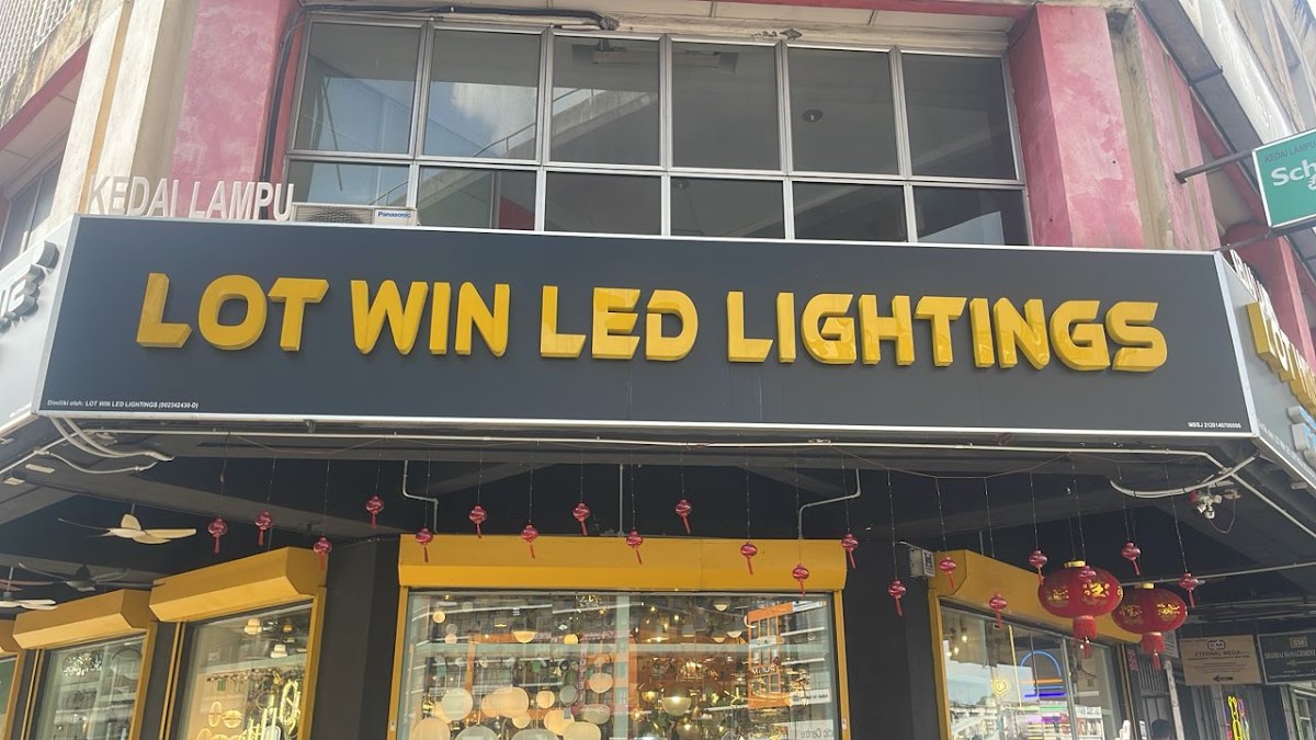 Black signboard with gold letters reading Lot Win LED Lightings above a glass shopfront full of lamps