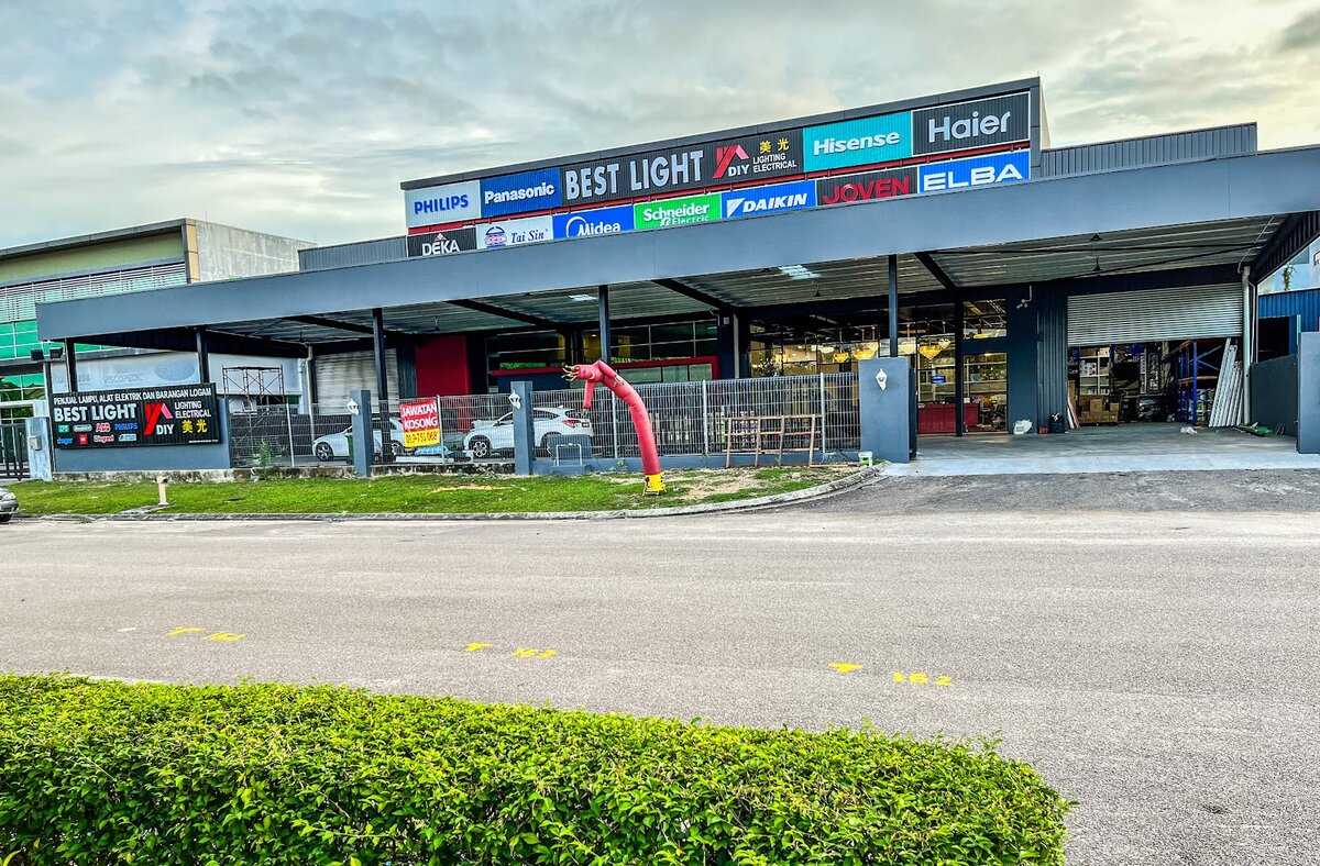 Large single-storey warehouse store with a Best Light DIY sign and a row of brand panels above a covered car porch