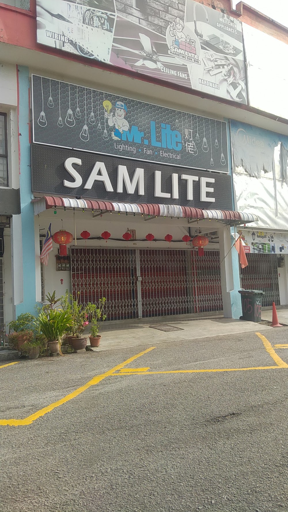 Shophouse with a grey Sam Lite signboard and a Mr. Lite sign above closed red shutters