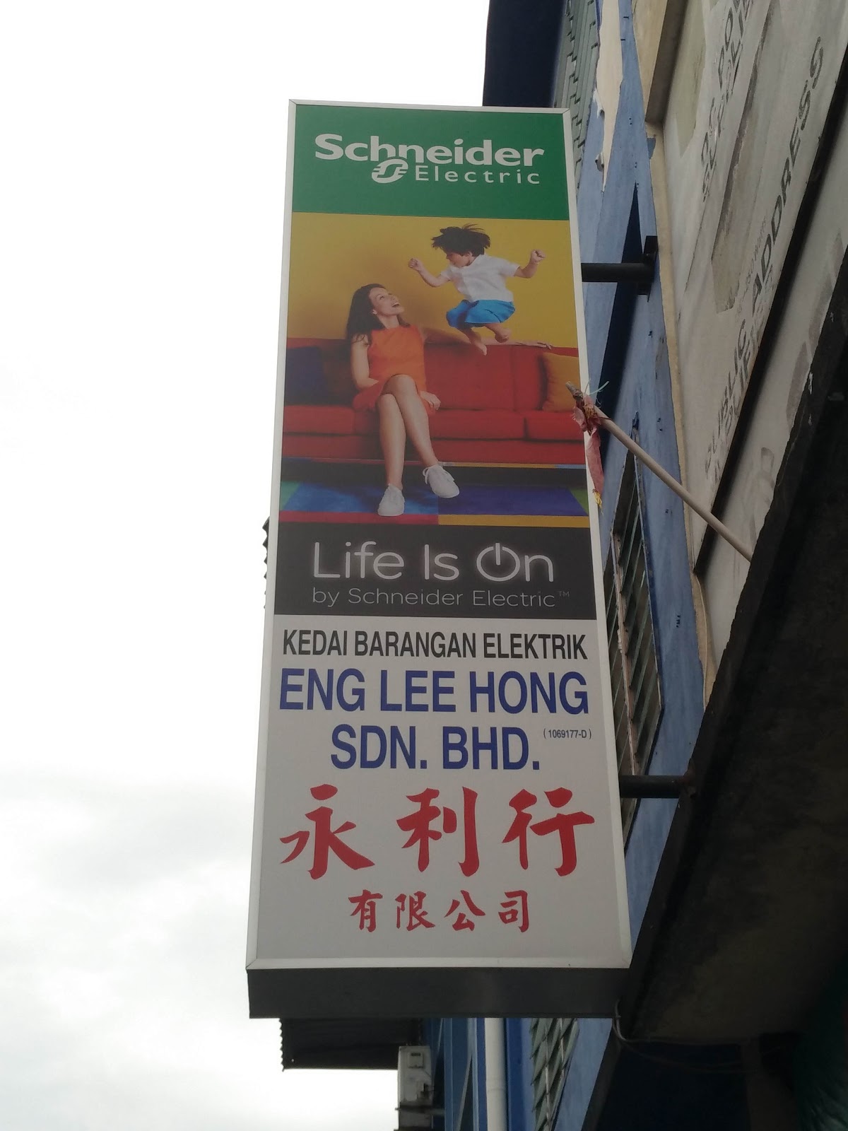 Vertical Schneider Electric lightbox sign with the Eng Lee Hong shop name in Malay, English and Chinese